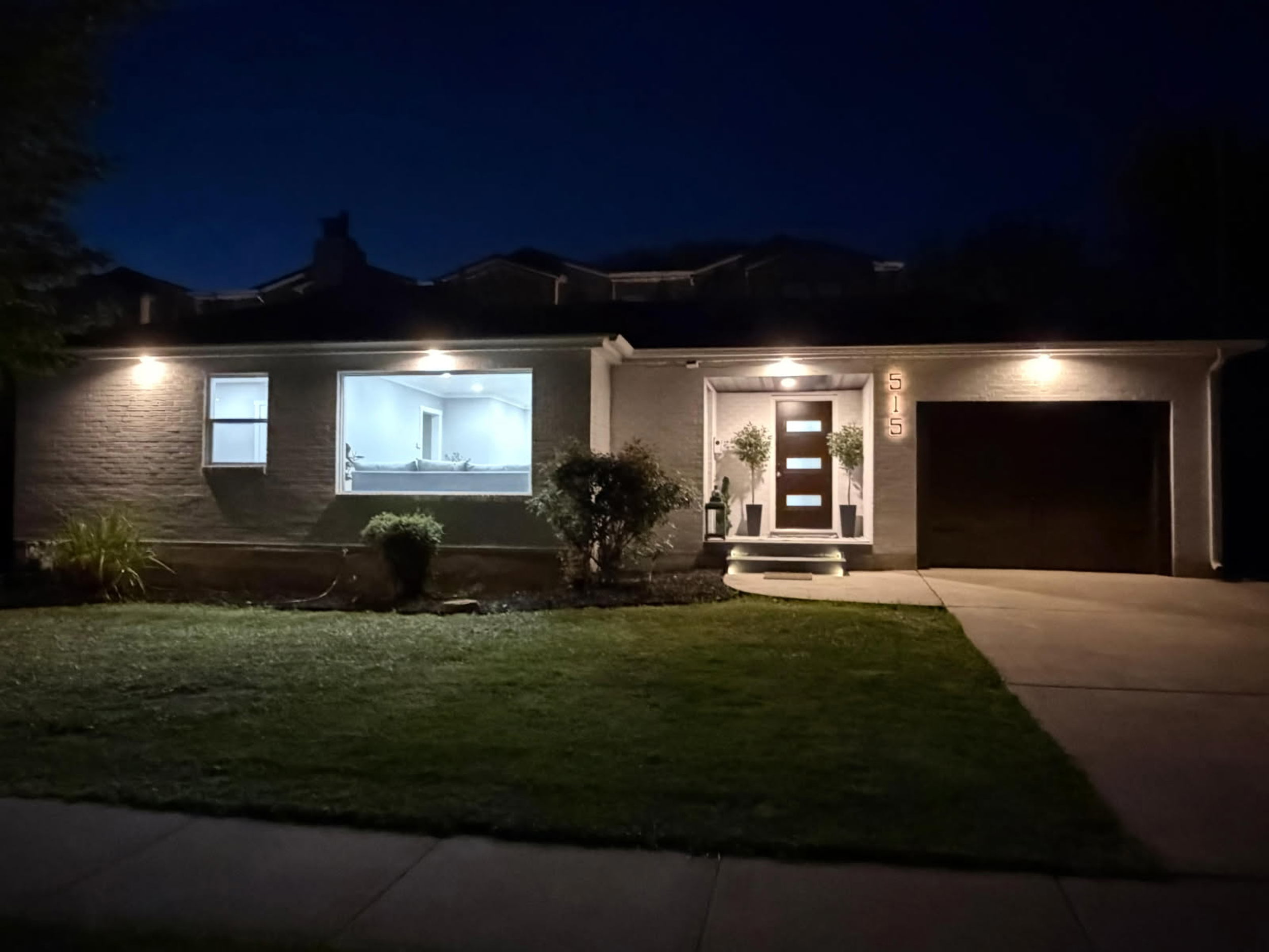 View of front facade with a yard, an attached garage, and driveway