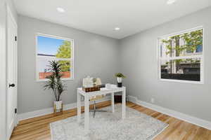Office area with light wood-type flooring and recessed lighting