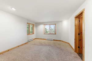 Spare room featuring carpet, a baseboard radiator, and recessed lighting