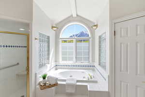 Full bathroom featuring a shower stall, a bath, and beamed ceiling