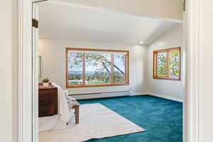 Unfurnished bedroom with dark carpet, a baseboard heating unit, multiple windows, recessed lighting, and lofted ceiling