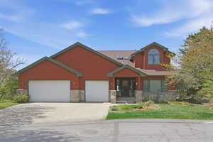 Craftsman inspired home with stone siding, driveway, a front yard, and an attached garage