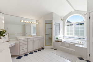 Bathroom featuring vanity, a bath, a stall shower, vaulted ceiling with beams, and light tile patterned flooring
