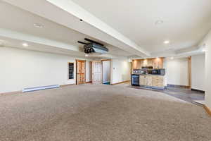 Unfurnished living room featuring wet bar, recessed lighting, light carpet, beverage cooler, and baseboard heating