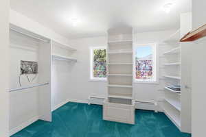 Walk in closet featuring dark carpet and a baseboard radiator