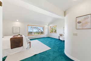 Unfurnished room with dark colored carpet, a baseboard radiator, recessed lighting, and vaulted ceiling
