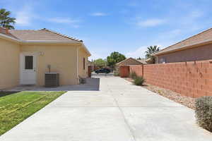 View of side of home featuring a gate, stucco siding, a tile roof, and a patio