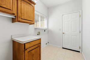 Laundry room featuring washer hookup, cabinet space, hookup for an electric dryer, and light tile patterned flooring