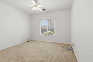 Empty room featuring light carpet and a ceiling fan
