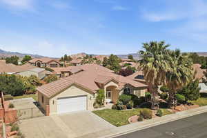 View of front facade with a garage, a residential view, stucco siding, driveway, and a gate