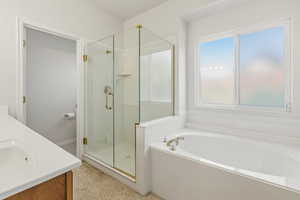 Bathroom with double vanity, a shower stall, and a bath