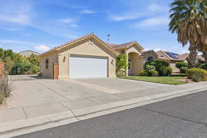 View of front of house featuring a garage, stucco siding, driveway, a tile roof, and a gate