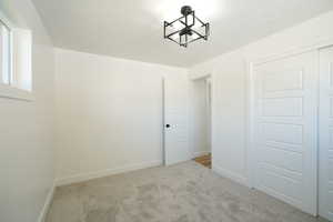 Unfurnished bedroom with light carpet and a closet