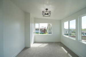 Empty room featuring light carpet and vaulted ceiling