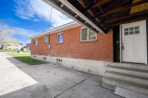 View of exterior entry featuring brick siding