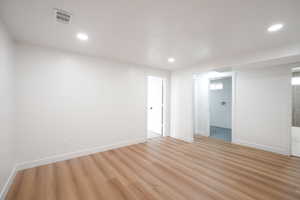 Spare room with light wood finished floors and recessed lighting