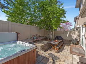Fenced backyard with a patio area and a hot tub