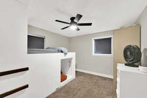 Bedroom with a ceiling fan and light colored carpet