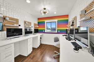 Office with dark wood-style floors and recessed lighting