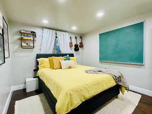 Bedroom with recessed lighting and dark wood-type flooring