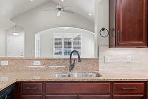 Kitchen featuring light stone counters, a ceiling fan, dishwasher, bold wood finish cabinetry, and recessed lighting