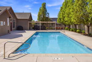Community pool featuring a patio area and a pergola