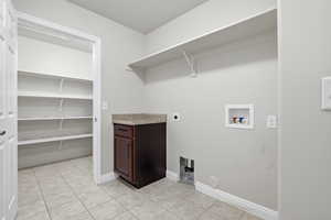 Laundry area featuring hookup for a washing machine, electric dryer hookup, very large storage closet