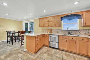 Kitchen featuring a peninsula, backsplash, a kitchen breakfast bar, recessed lighting, and light stone counters