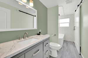 Bathroom featuring vanity, light wood-type flooring, a tub to relax in, and a shower