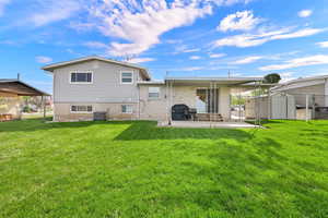 Back of property featuring a patio area, a storage unit, and brick siding