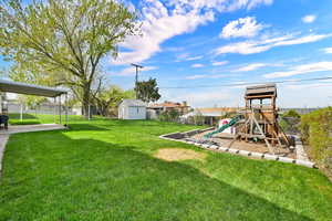 Fenced backyard featuring a playground
