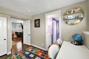 Home office featuring baseboards and dark wood-type flooring