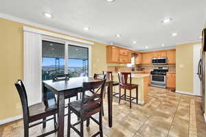 Dining room with ornamental molding and recessed lighting