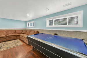 Playroom with dark wood finished floors, a wainscoted wall, and recessed lighting