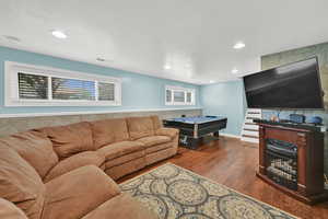Living area with wood finished floors, plenty of natural light, a textured ceiling, and recessed lighting