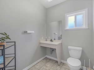 Bathroom featuring toilet and light tile patterned flooring
