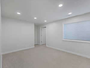 Empty room with recessed lighting and light carpet