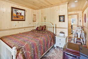 Bedroom with wooden ceiling and wooden walls