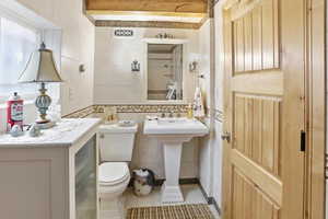 Bathroom featuring tile walls, light tile patterned floors, and a shower