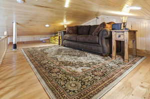 Living area featuring light wood-type flooring, wooden walls, and wooden ceiling