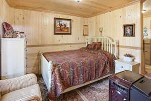 Bedroom with wooden walls and wood ceiling