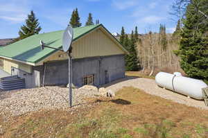 View of side of home with a metal roof and an outdoor structure