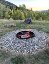 Yard at dusk featuring an outdoor fire pit and a yard