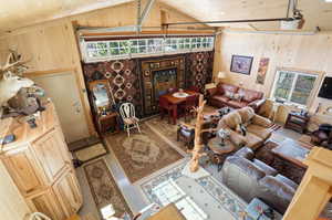 Living area with wood ceiling, tile patterned floors, and wood walls