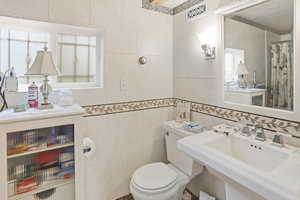 Bathroom with tile walls and a shower with curtain