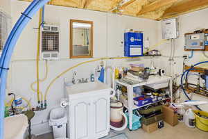 Miscellaneous room with water heater, heating unit, and concrete flooring