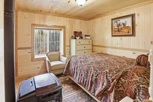 Bedroom featuring wood walls, wood finished floors, and wooden ceiling