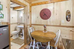 Dining space featuring wooden walls and light tile patterned flooring