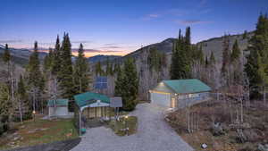 Ranch-style house with solar panels, a mountain view, an outdoor structure, a garage, and driveway