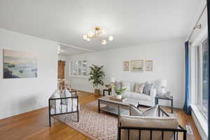 Living area featuring hardwood / wood-style floors, a barn door, and suspended lighting